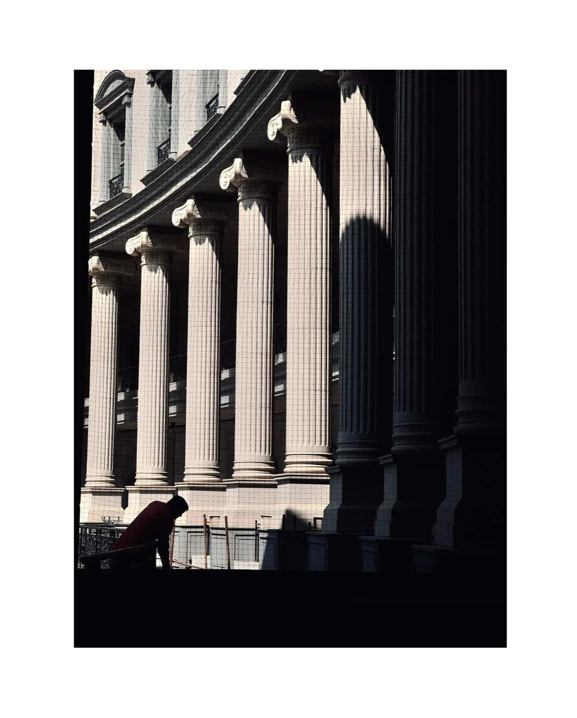Sunlit classical columns receding into deep shadow